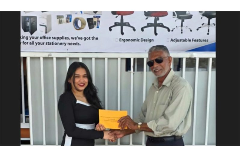 Regal Stationery and Computer Centre Sales Representative, Anuradha Bahadur, hands over cheque to DCB Secretary, Davteerth Anandjit.