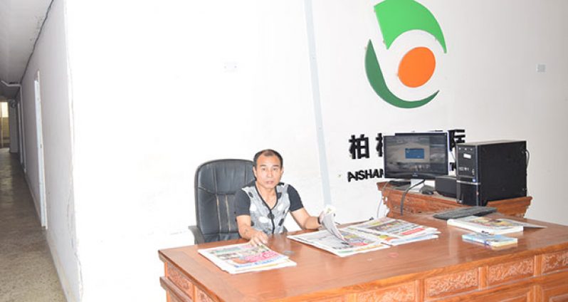 A Chinese national sits at the front desk of what was Baishanlin’s Providence, East Bank Demerara office