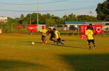 Excelsior Academy (Black kit) & Buxton Secondary (Neon green) players vie for the ball