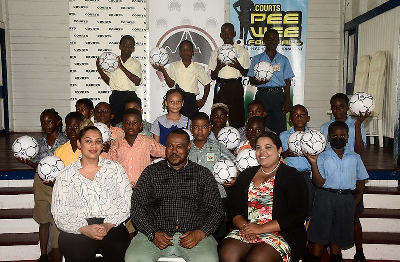 Some of the Under-11 Pee Wee footballers who will be participating in this year's competition pose with officials. In front row from left: COURTS Brands Manager Krystal Van Sluytman, Co-Diredtor of Petra Organisation Troy Mendonca Nareeza Latif
(Adrian Narine photo)
