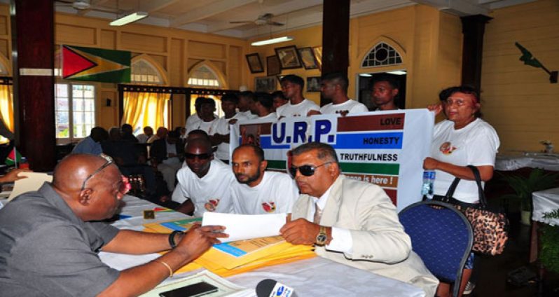 GECOM's Chief Elections Officer Keith Lowenfield makes a point to United Republican Party Leader Vishnu Bandhu on Nomination Day (Adrian Narine photo)