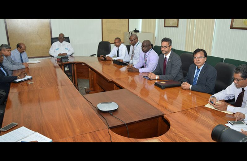 Minister of Finance , Winston Jordan (centre ) , Junior Minister of Finance , Jaipaul Sharma (second from left ) and Bank of Guyana governor , Dr Gobind Ganga (third from left ), sit alongside officials of the Guyana Association of Bankers prior to a meeting between both parties on Friday.