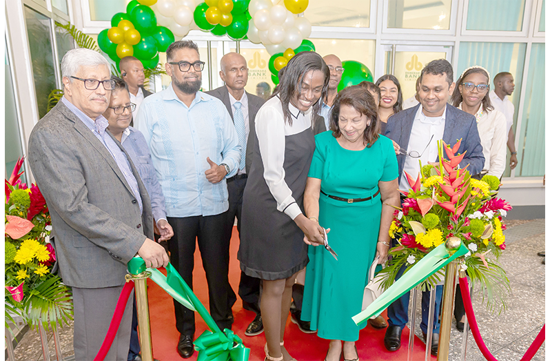 President Dr. Irfaan Ali observes as the ceremonial ribbon is cut to declare open the new Demerara Bank’s Beterverwagting, East Coast Demerara, branch, on Monday (Delano Williams photo)