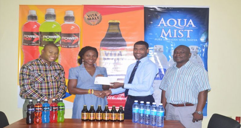 Aqua Mist Brand manager Errol Nelson makes the donation to Games organiser Noshavyah King of Genesis Fitness Express while Communications manager Troy Peters and Brand manager Colin King look on.