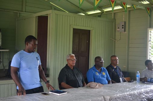Baracara-(1) (L to R) Assistant Chairman of Baracara, Glenton La Fleur (standing); Minister of Agriculture Noel Holder; CEO, GLDA, Nigel Cumberbatch and Prime Minister Moses Nagamootoo’s Region Six representative Gobin Harbhajan are seated at a table during Thursday’s outreach to Baracara, Region Six.