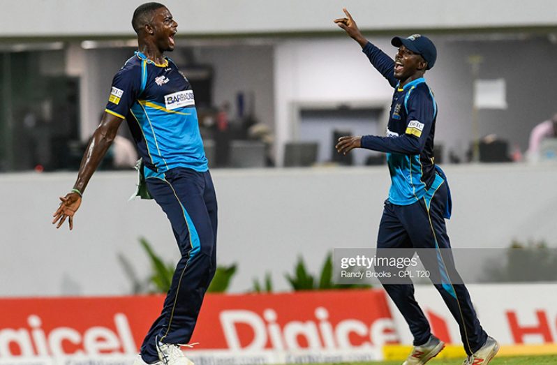 In this handout image provided by CPL T20, Jason Holder (L) and Hayden Walsh Jr. (R) of Barbados Tridents celebrate the dismissal of Andre Fletcher of St Lucia Zouks during match 26 of the Hero Caribbean Premier League between Barbados Tridents and St Lucia Zouks at Kensington Oval on September 29, 2019 in Bridgetown, Barbados. (Photo by Randy Brooks - CPL T20/Getty Images)