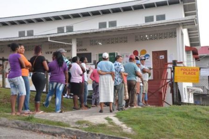 These persons gathered at the Hill View Polling Station were anxiously awaiting the opening of polls. [Delano Williams photo]