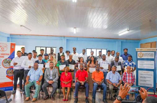 Minister of Labour and Manpower Planning, Keoma Griffith (seated centre), flanked by officials and some of the graduates