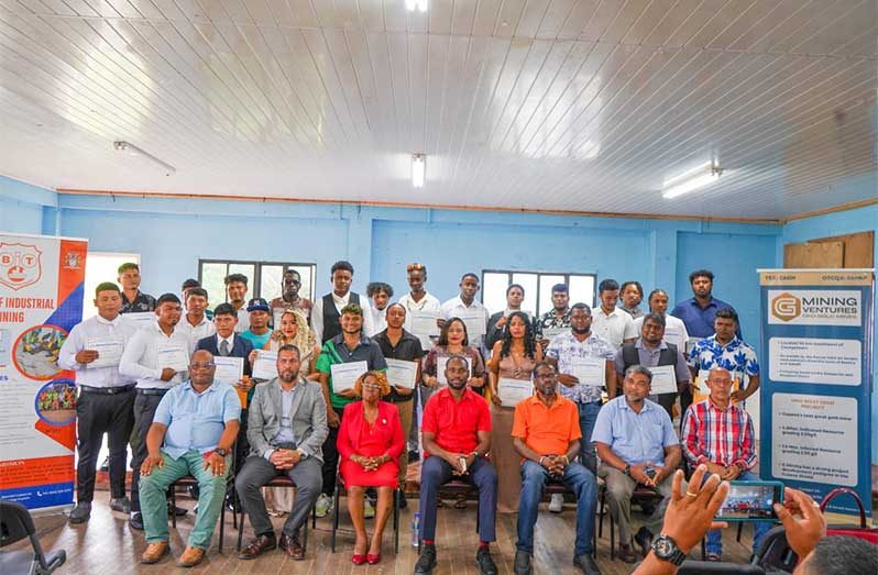 Minister of Labour and Manpower Planning, Keoma Griffith (seated centre), flanked by officials and some of the graduates