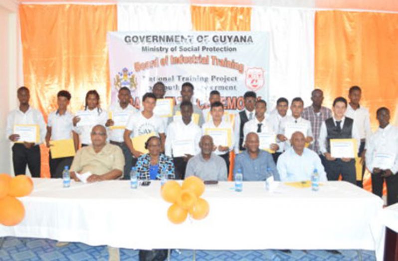 From left to right- Assistant Director of the National Community Development Councils (NCDC), Donald Ainsworth; Permanent Secretary in the Ministry of Social Protection, Lorene Baird; Minister within the Ministry of Social Protection, Keith Scott; Heavy Duty Equipment Operation Officer, Earl Pestano and Executive Development Officer of the Hope Foundation, Ivor Melville, along with the 25 graduates.