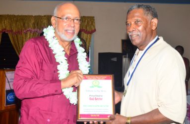 In this Adrian Narine photograph, the 80-year-old Basil Butcher (right), proudly accepts his plaque from President Donald Ramotar.