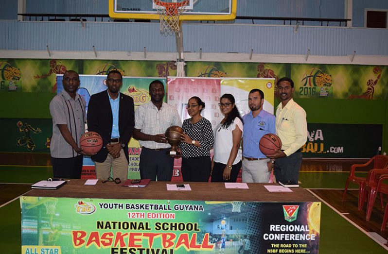 YBG Director Chris Bowman (3rd from left) collects the symbolic trophy from Monique Tewari, of the Beharry Group of Companies while other members of the launch party inclusive of GABF vice-president Kendrick Thomas (left), Director of Sport Christopher Jones (2nd from left), Ministry of Education representative Nicholas Fraser (2nd from right) and YBG co-Director Rayad Boyce (right) share the moment