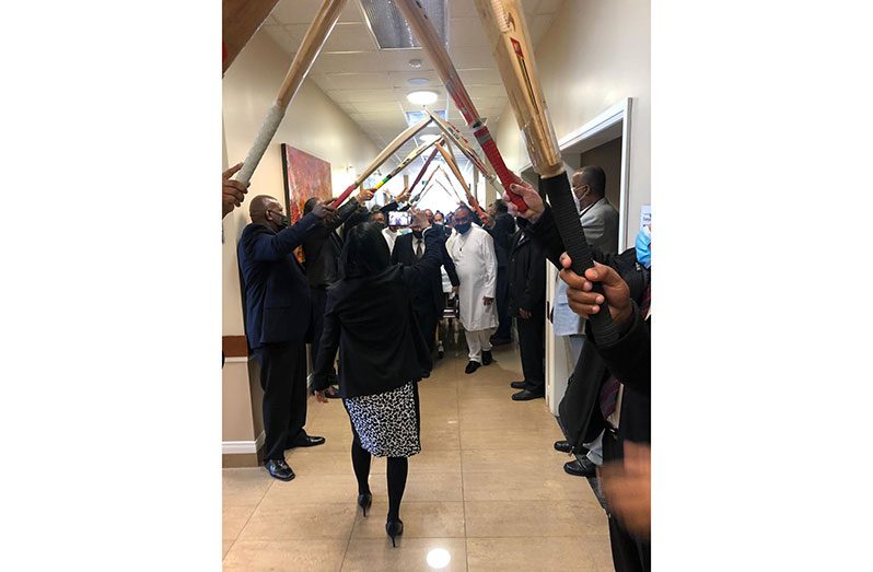 Present and former cricketers plus well wishers form a bat arch to pay their last respects to Jadunauth.