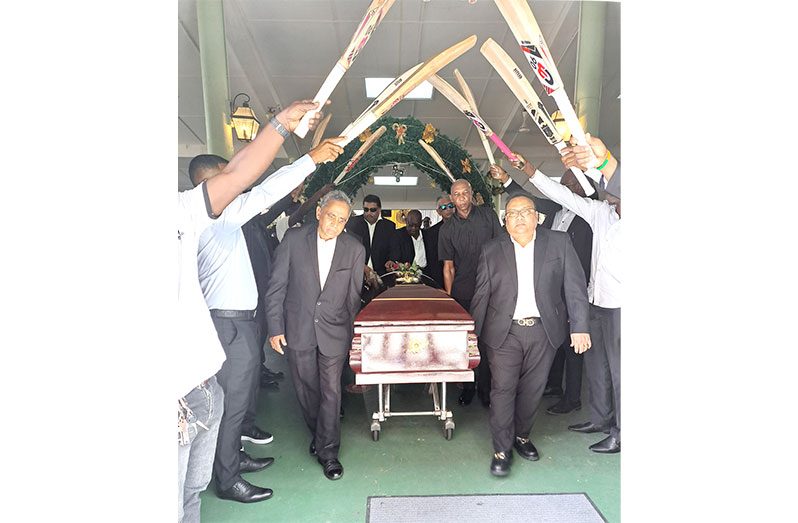 GCB President Bissoon Singh (front right) and his executives carry the casket of the body of Clyde Butts through a bat arch by former national cricketers from the Church yesterday (Sean Devers)