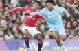 Manchester United midfielder Kobbie Mainoo and Nottingham Forest defender Ola Aina battle for possession at Old Trafford