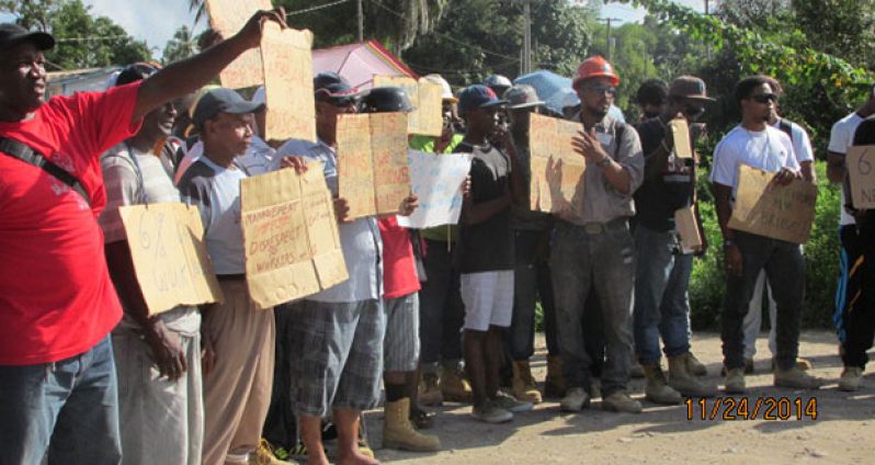 Disgruntled workers gather outside the north gate of the Linden bauxite operations of the Bosai Minerals Group on Monday