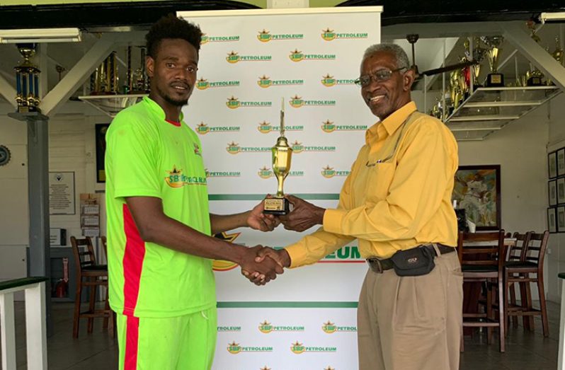 Man-of-the-match Ronsford Beaton(left) accepts his trophy from match referee Grantley Culbard.