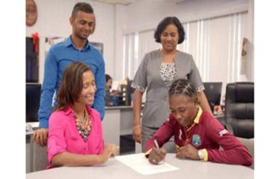 Its official! Beharry’s Marketing Executive Anjuli Beharry-Strand (seated left) watches on as Shemaine Campbelle signs her contract.
