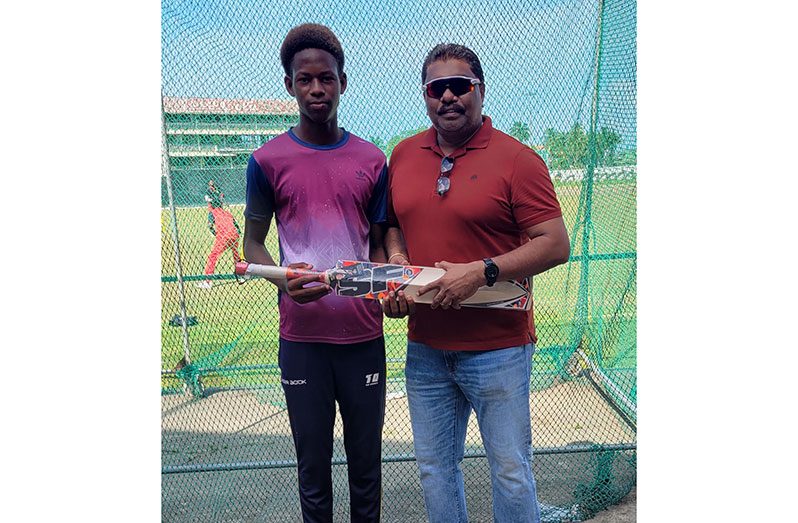 Jeremiah Hohenkirk (left) collects bat from GCB executive member, Anil Beharry.