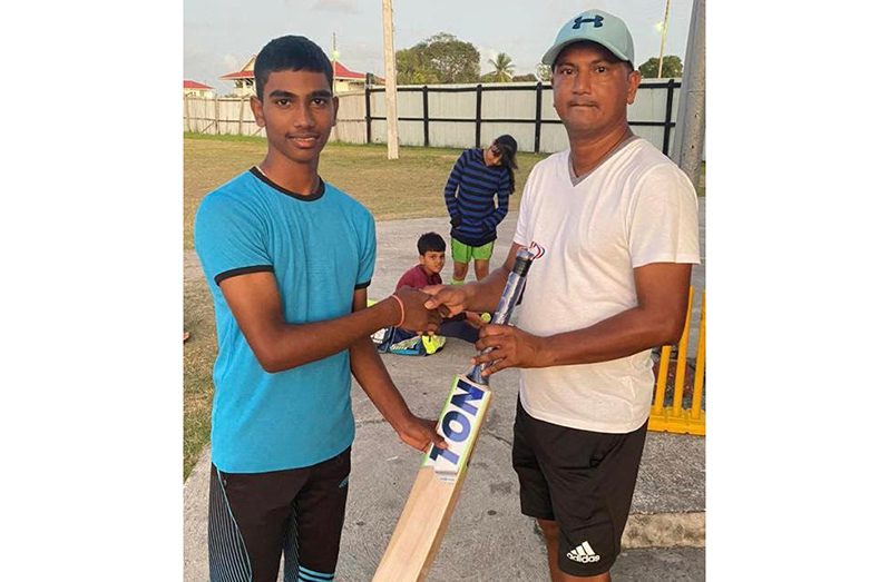 Romario Ramdeholl (right) is presented with his cricket gear.
Photo saved: Romario
Avishkar Beharry (left) receives his cricket gear.