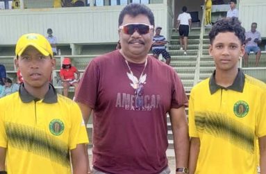 Anil Beharry (centre) with the two Under-13 cricketers.