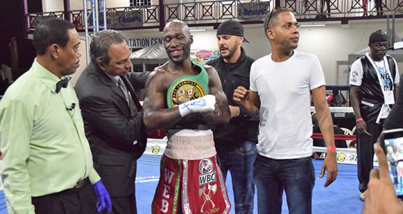 GBBC’s president Peter Abdool (second left) places the WBC’s FECABOX lightweight title belt on USVI’s Demarcus `Chop Chop) Corley after he defeated Guyana’s Dexter Gonsalves for the title on Saturday evening at the Giftland Mall, ECD (Cullen Bess-Nelson photoS).