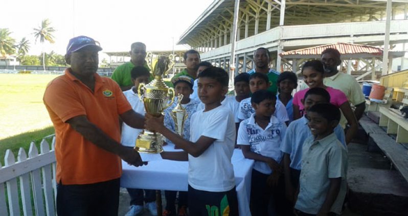 Sales Representative Yougeshwar Seepersaud presents the winning trophy to Belvedere Primary captain Altaf Zaheer.