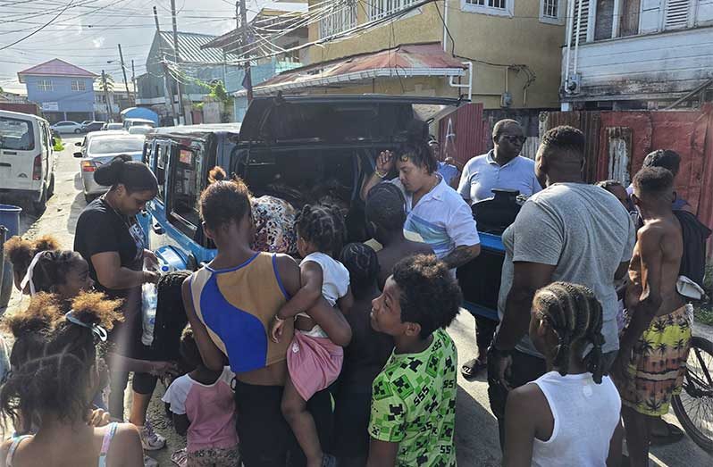 Businessman and gold miner Paul Chow, along with his wife Rayana, in Albouystown sharing out breakfast supplies within the community