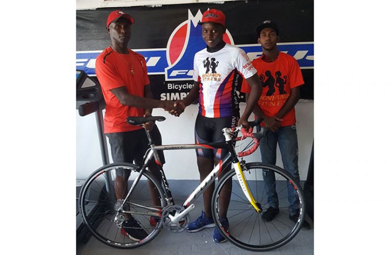 Wilbert Benjamin presents racing bike to one of the top Junior cyclists of Berbice last year.