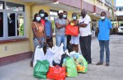 Minister of Home Affairs, Robeson Benn, provides relief items to the fire victims