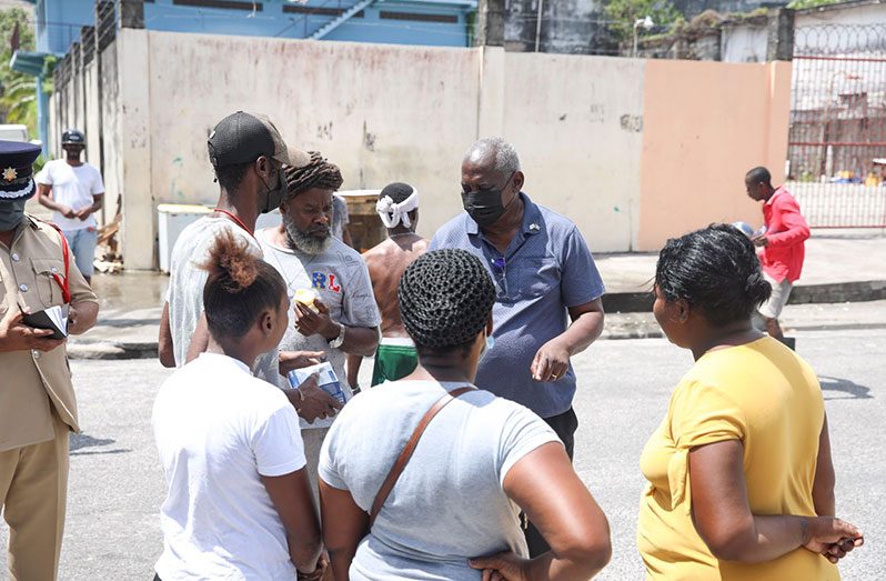 Home Affairs Minister, Robeson Benn, distributing smoke detectors to some of the residents of Tiger Bay, Georgetown on Sunday during a walkabout exercise