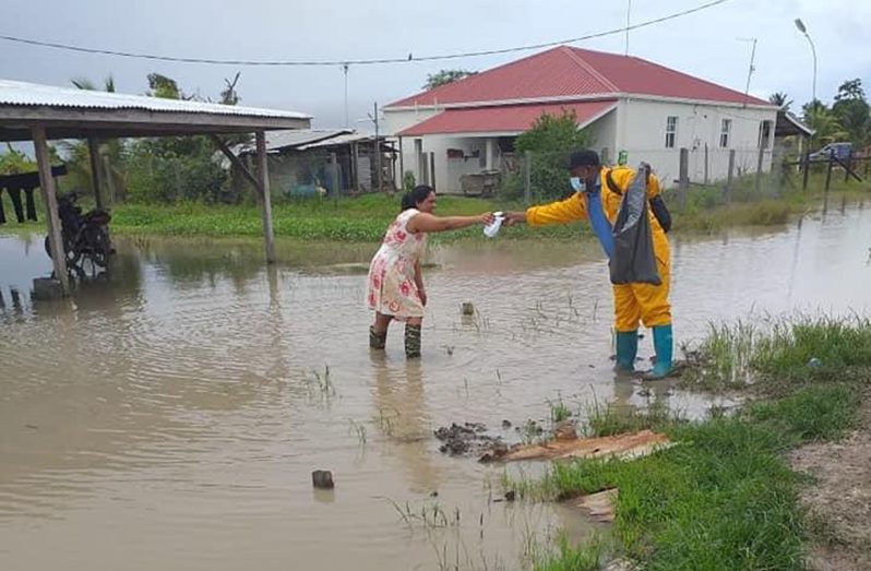 A doctor distributes medication to a resident in a flood-affected community