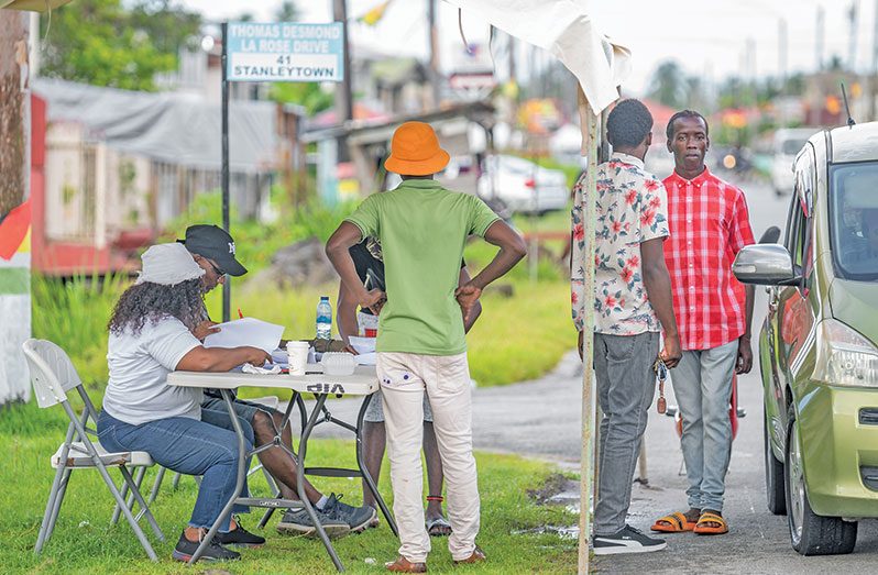 Voters checking for their names at a polling place in Stanleytown village (Delano Williams photo)