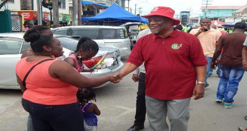 Prime Minister Samuel Hinds interacting with a Berbice resident at the Mash Parade