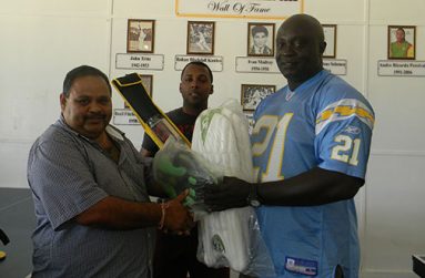 GCB president Drubahadur (left) hands over the kit to Skeldon CDO Linden Murray, in the presence of BCB head coach Julian Moore.