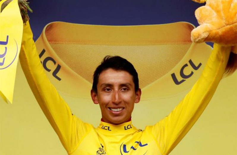 Team INEOS rider Egan Bernal of Colombia celebrates on the podium, wearing the overall leader's yellow jersey. (REUTERS/Gonzalo Fuentes)