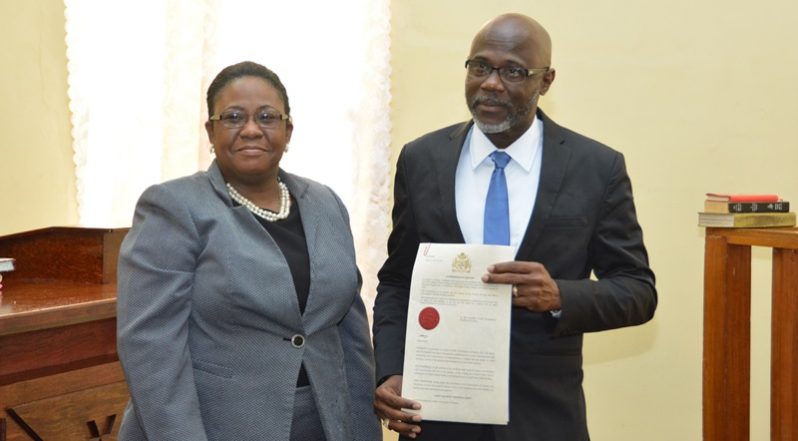 Presidential Advisor on the Environment, Rear Admiral (ret’d) Gary Best displays the  commissioning instrument as he stands beside Chief Magistrate Ann McLennan at the close of the ceremony.