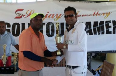Winning rookie Mahendra Bhagwandin (left) smiles proudly as he accepts his souvenir golden golf club from Managing Director of Sanjay’s Jewellery, Sanjay Persaud after dominating last Sunday’s tournament.