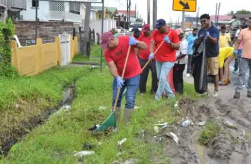 Natural Resources Minister, Vickram Bharrat, takes part in ‘operation clean up’, along the Grove main road, East Bank Demerara, on Sunday (DPI photo)
