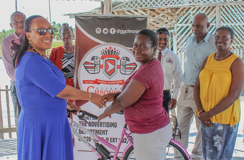 GNNL’s Administrative Manager, Donna Todd flanked by the General Manager Sherod Duncan, other managers and staffers as she made the donation of a bicycle to Chronicle vendor Tessa Waterton on Monday at Yarrowkabra (Vishani Ragobeer photos).