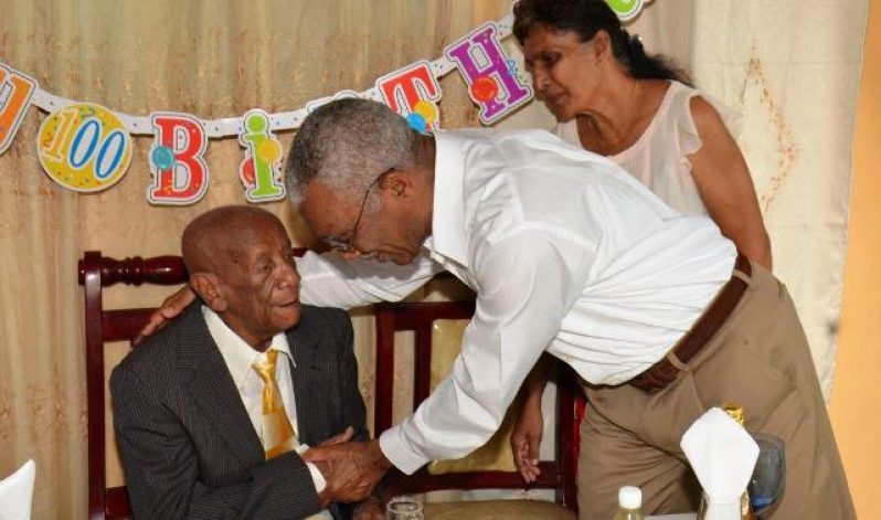 President Granger congratulates Mr Charles Allicock on his 100th birthday. Also in photo is Mr Allicock’s caretaker, Bibi Fagu (Sandra Prince/Ministry of the Presidency photo)