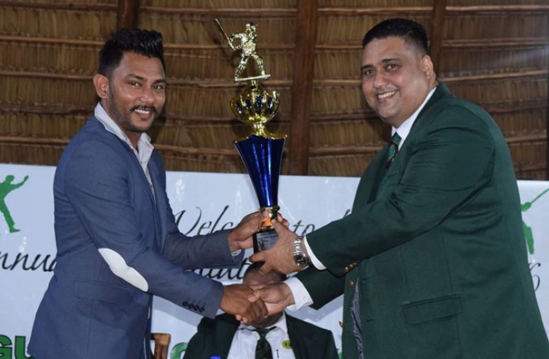 Devendra Bishoo receives his trophy from GCB Treasurer and WICB Director Anand Kalladeen.