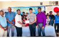 Former West Indies leg-spinner, Devendra Bishoo (third left), hands over the sponsorship cheque on behalf of Nizul Hussain to Secretary Naieem Khan in the presence of President Vemen Walter (right) and other executives of the club and young cricketers