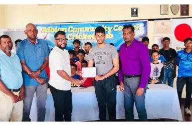Former West Indies leg-spinner, Devendra Bishoo (third left), hands over the sponsorship cheque on behalf of Nizul Hussain to Secretary Naieem Khan in the presence of President Vemen Walter (right) and other executives of the club and young cricketers