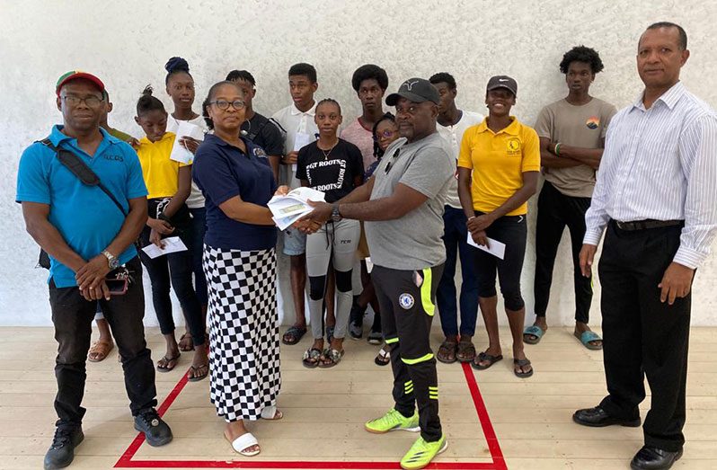 Team manager Nadine Trotz receives the tokens from Leslie Black in the presence of Lyndon 'Jumbie' Jones (left), AAG president Aubrey Hutson (right) and athletes