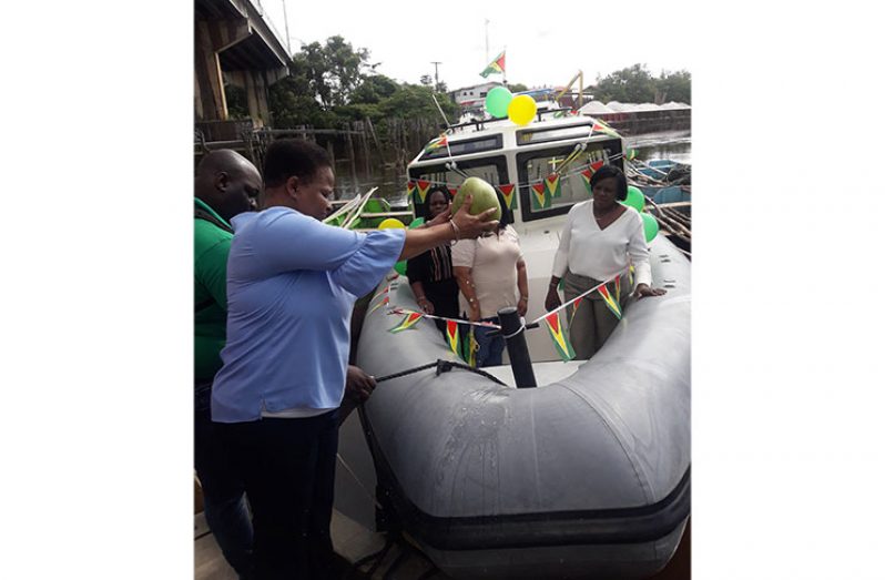 Minister of Public Health, Volda Lawrence blessing the vessel with coconut water at the commissioning ceremony at the Canje Creek on Monday