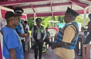 Police ranks interacting with one of the boat operators during the joint marine patrol exercise