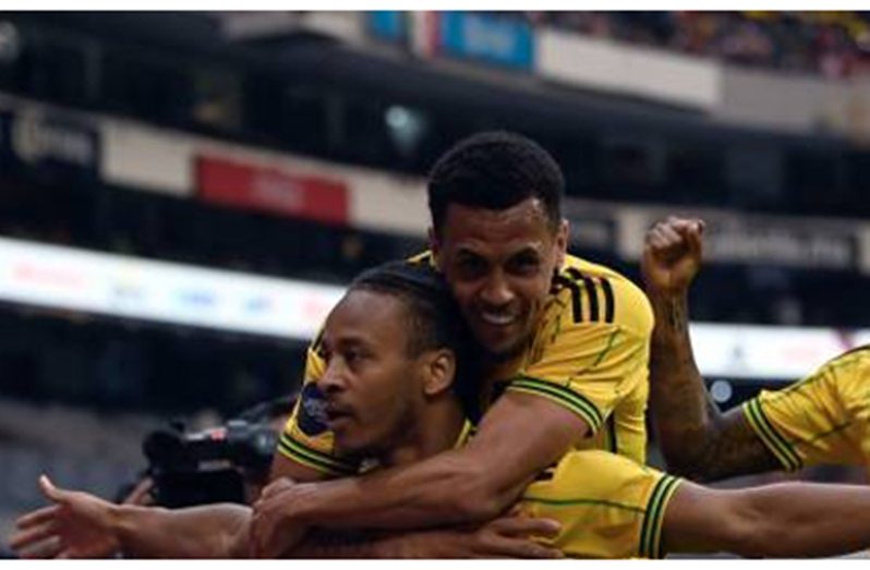 Bobby Reid (front) is joined by teammate Ravel Morrison after scoring Jamaica’s opener on Sunday.