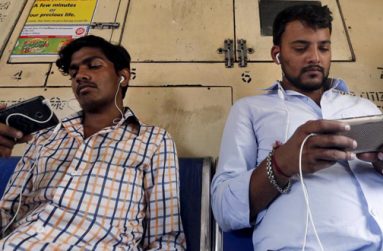 Commuters watch videos on their mobile phones as they travel in a suburban train in Mumbai, India, April 2, 2016. (REUTERS/Shailesh Andrade)