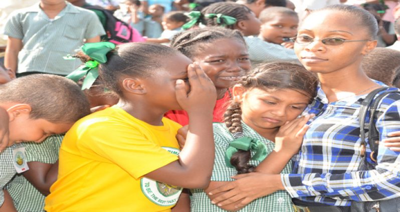 Students of the St Margaret's Primary School surround a teacher for comfort after a bomb scare at the school earlier today.